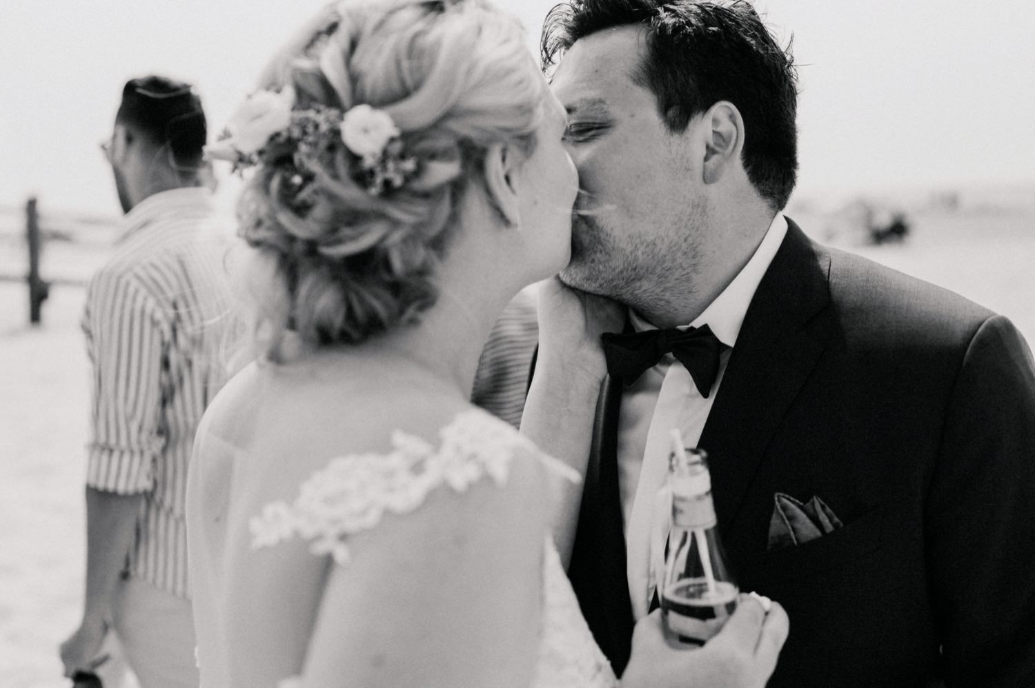 Braut und Bräutigam küssen sich am Strand von Sankt Peter-Ording