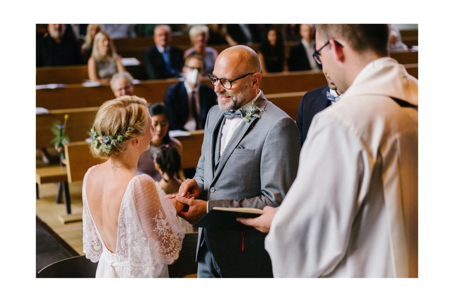 Der Bräutigam steckt seiner Braut beim Eheversprechen den Ehering in der 60er Jahre Kirche in Bergedorf an