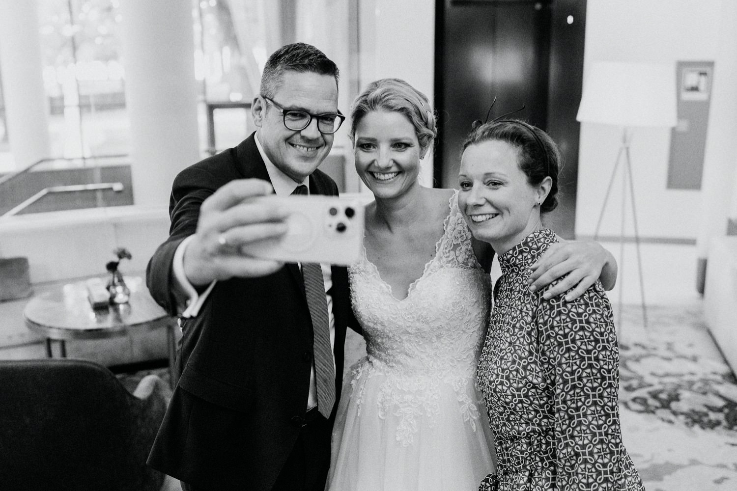 Gäste machen mit der Braut ein Selfie beim Empfang der Hochzeit an der Alster im 5 Sterne Hotel The Fontenay