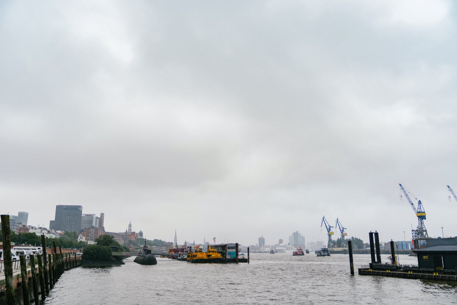 Blick auf den Hamburger Hafen bei diesigem Wetter und grauen Wolken vom Fischmarkt aus gesehen